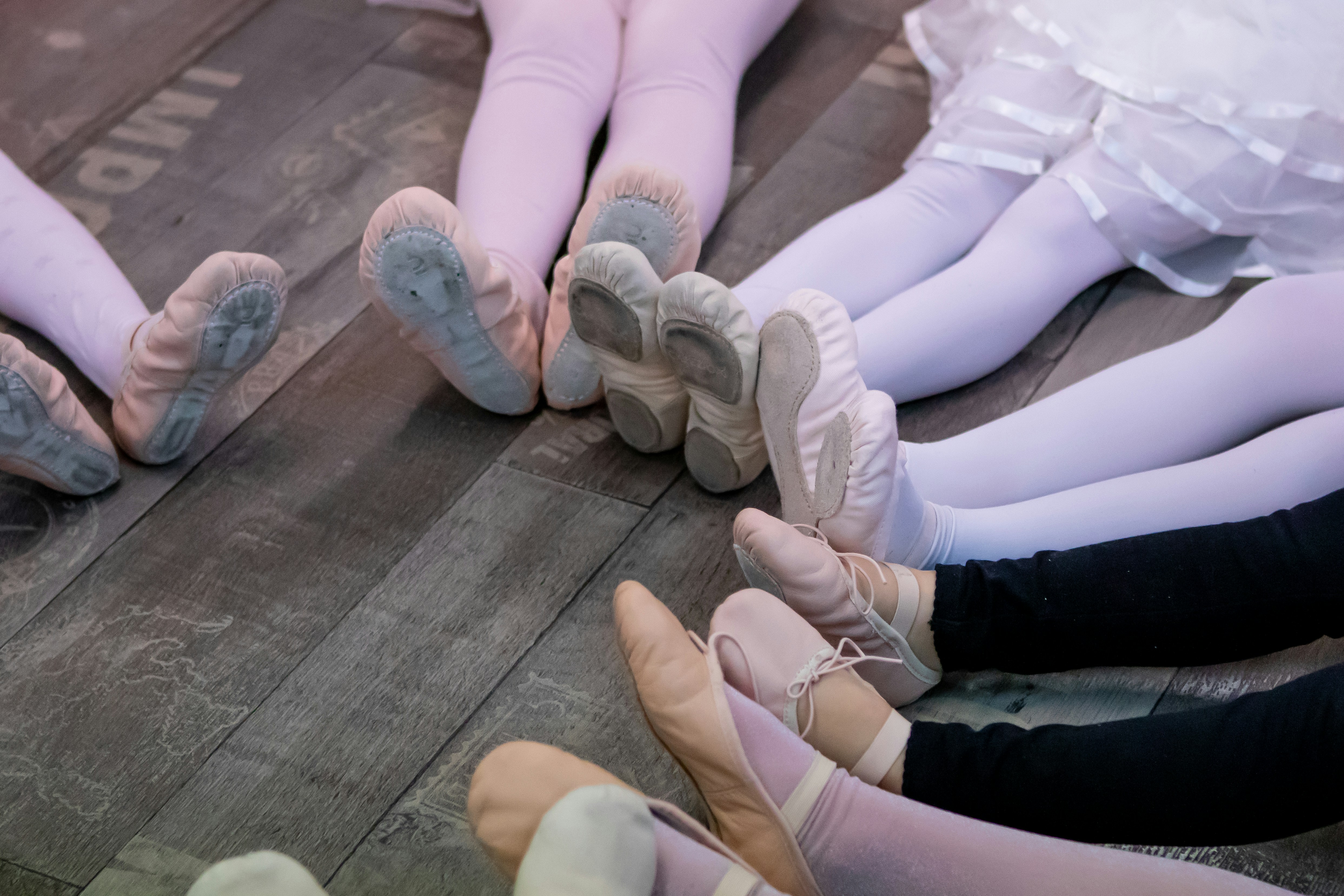 kids in a circle in ballet shoes